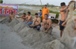 Activists bathe with sand to protest against Yamunas depleting waters